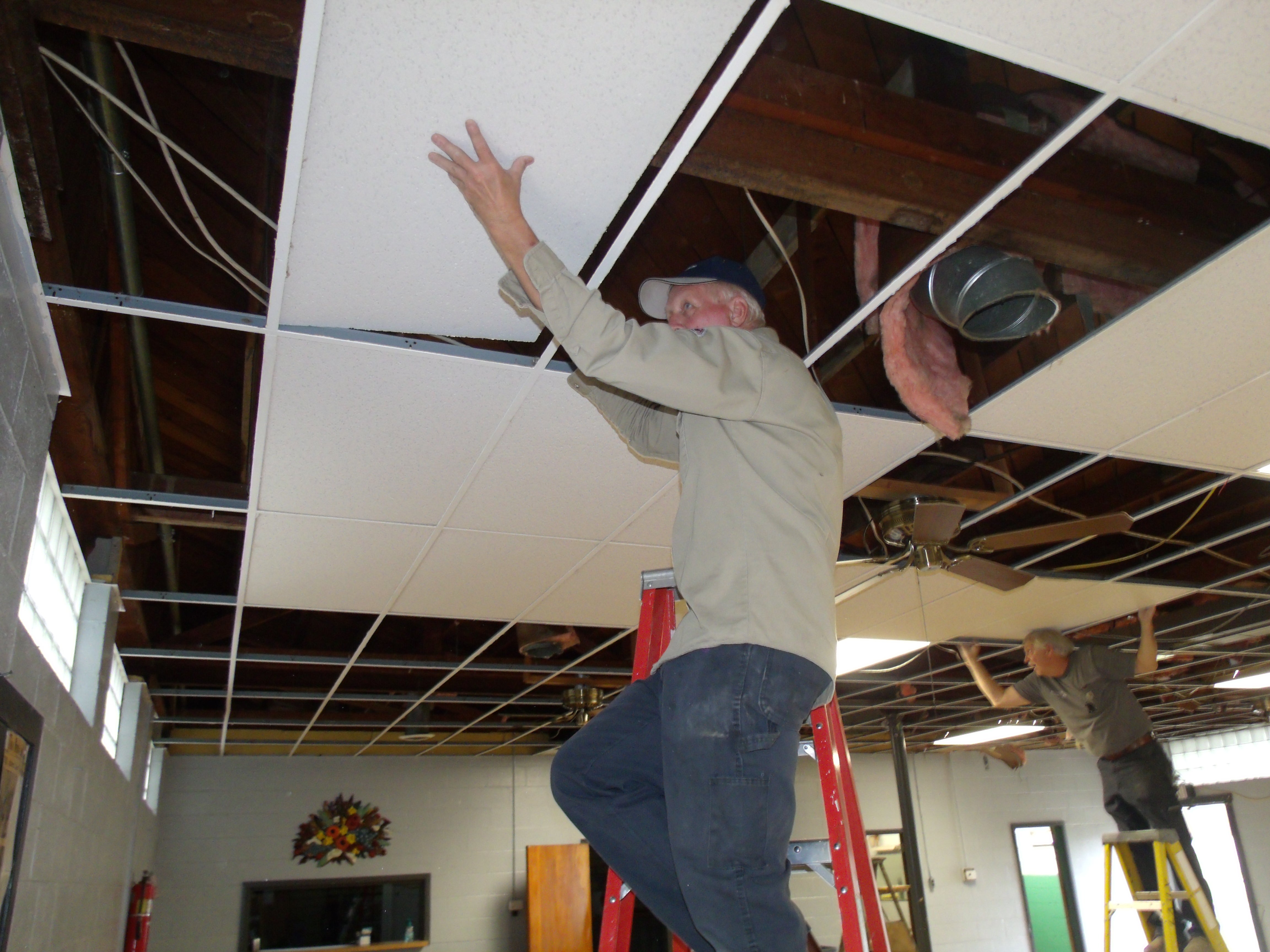 Linemen installing ceiling tiles.